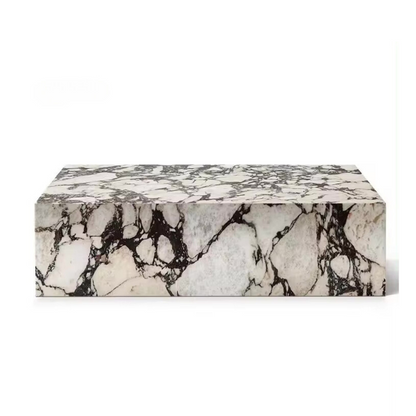 The Calcutta Viola Marble Coffee Table is a rectangular marble block with a white base and distinctive black veining patterns.