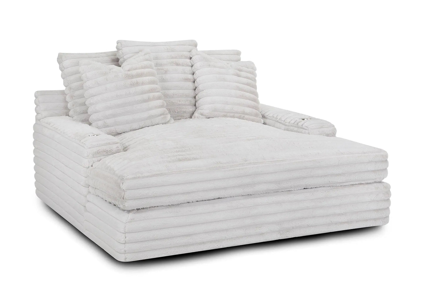 The Oasis Snuggle Chaise, a spacious white ribbed lounge, is adorned with several matching pillows.