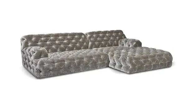 The Coco Miralda Sofa is a gray velvet tufted sectional with a chaise lounge on the right side, featuring deep button detailing on the back, seat, and arms.