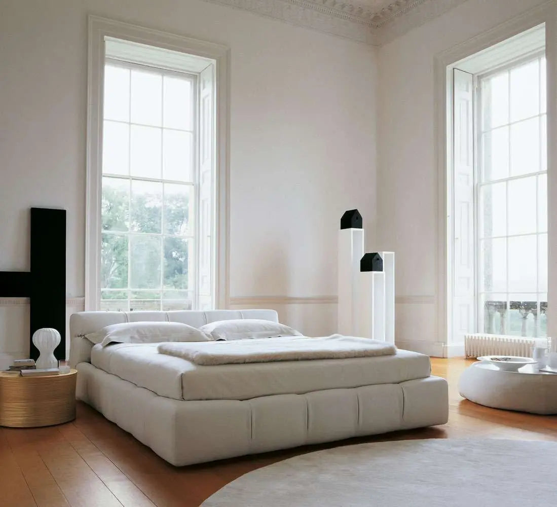 Modern minimalist bedroom featuring the Modern Zen Bed in white, complemented by large windows, a hardwood floor, and decorative black and white accents.