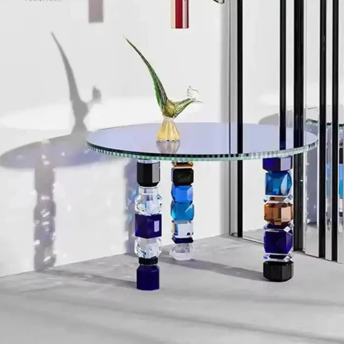 The Luxury Glass Coffee Table, featuring decorative, multicolored geometric legs, was elegantly displayed in a minimalist room with a glass bird sculpture serving as its centerpiece.