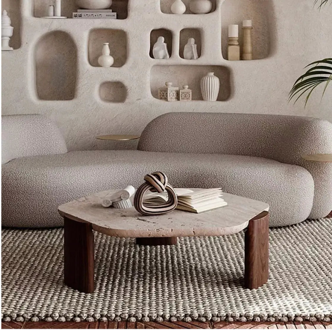 Minimalist living room with a neutral color palette featuring a curved sofa and a Nordic Lob Low Table with decorative items.